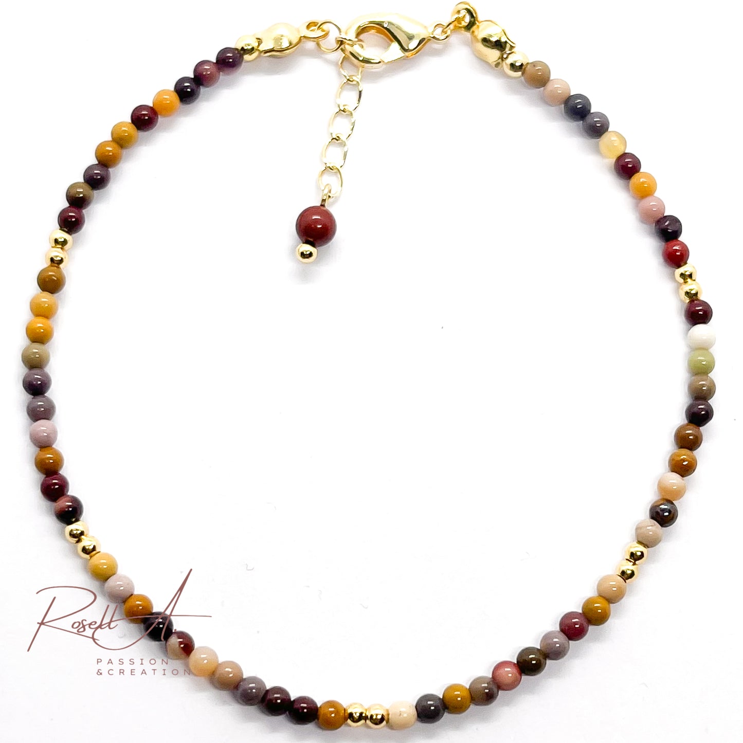 Filigranes Mokait Armband mit herbstlichem Farbverlauf und goldenen Details, flach fotografiert