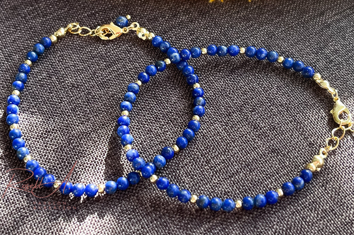 Nahaufnahme des Lapislazuli-Armbands bei Tageslicht auf dunkelbraunem Leinenstoff