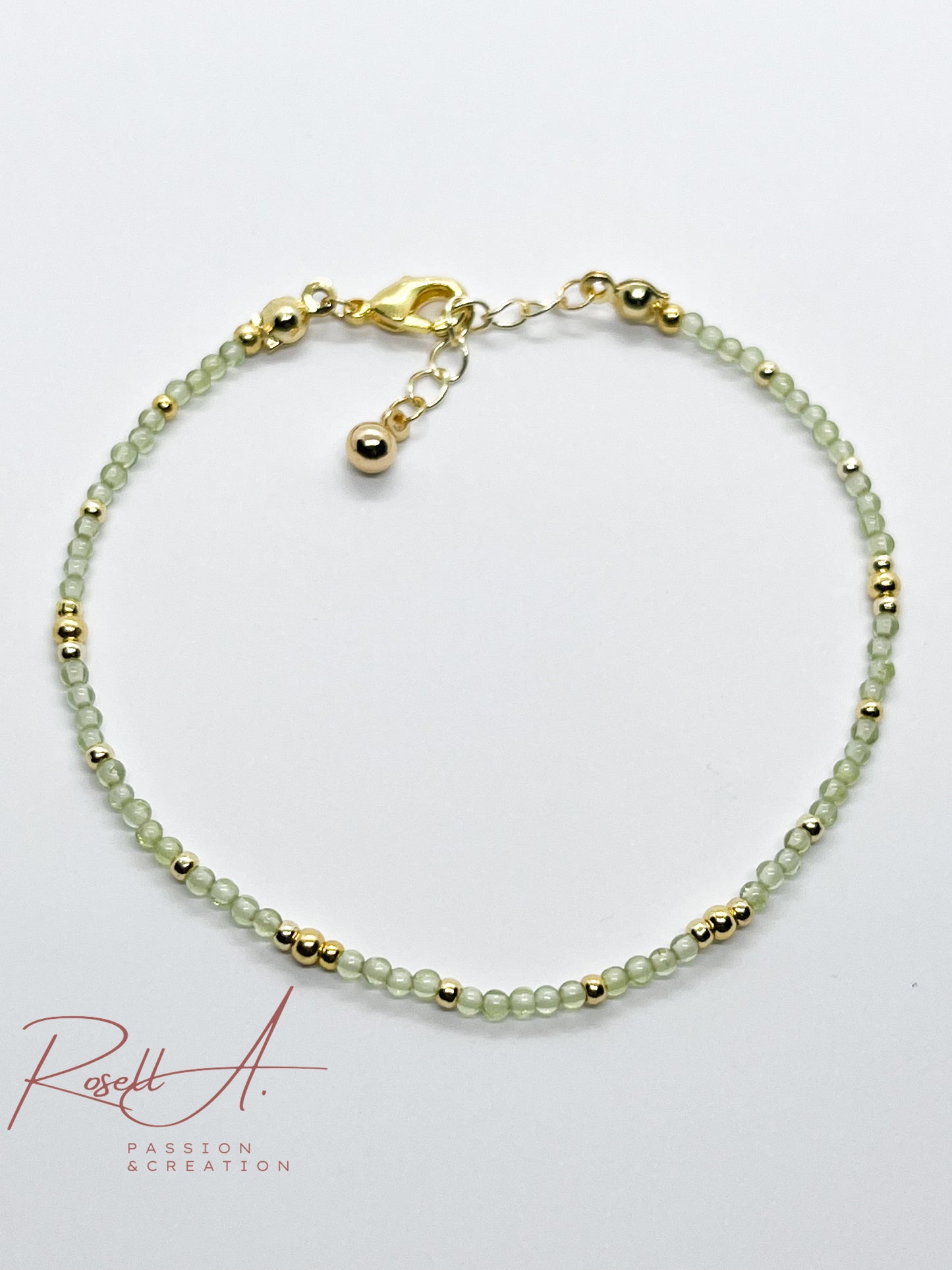 Draufsicht auf das Armband mit facettierten grünen Peridotperlen und vergoldeten Zwischenperlen