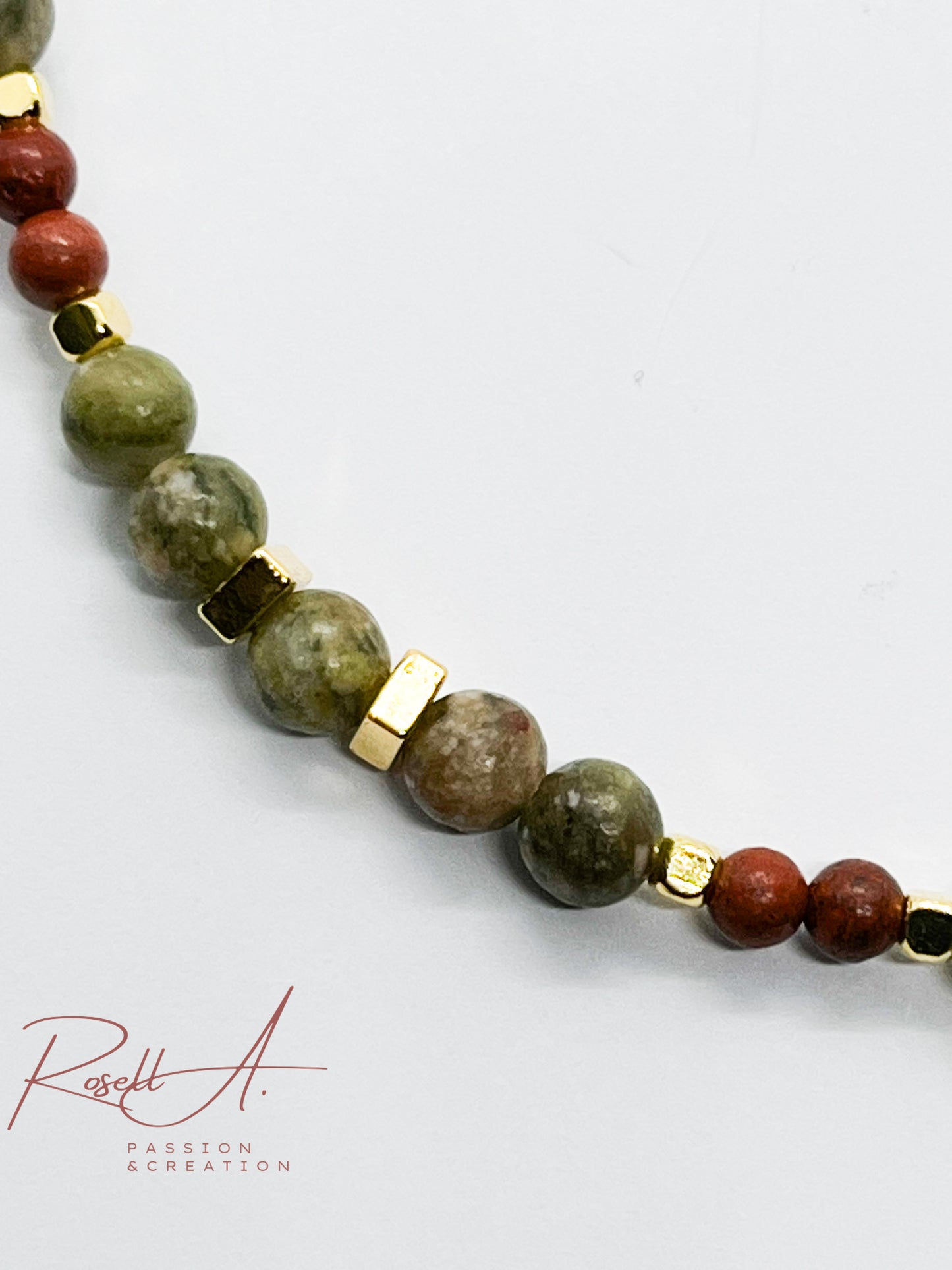 Detailaufnahme des Armbands mit kubischen Zwischenperlen und handgefertigtem Charm aus rotem Jaspis