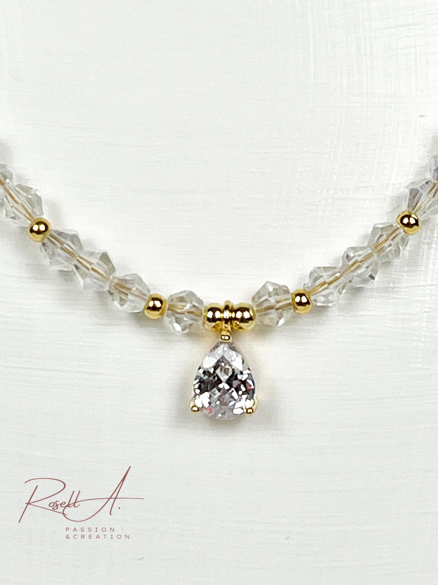 Elegante vergoldete und feine Kette mit glänzenden Elementen aus weißer Glaskristall und Zirkon.