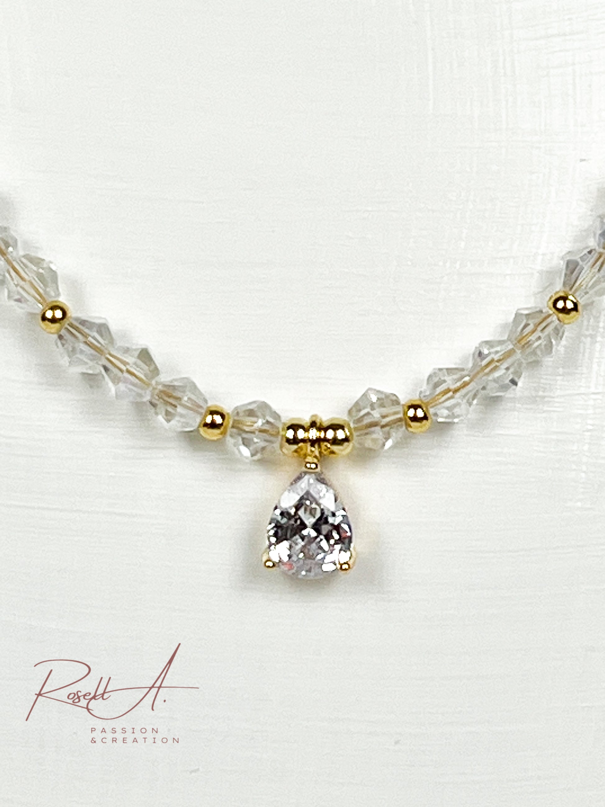 Elegante vergoldete und feine Kette mit glänzenden Elementen aus weißer Glaskristall und Zirkon.